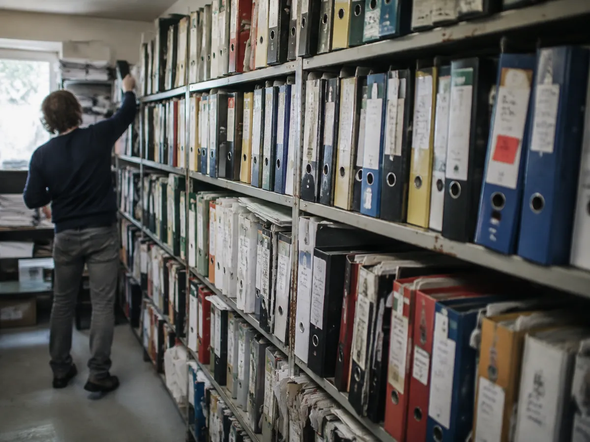 Archivregal mit über Jahre gewachsenen Ordnern in unterschiedlichen Farben und Beschriftungen