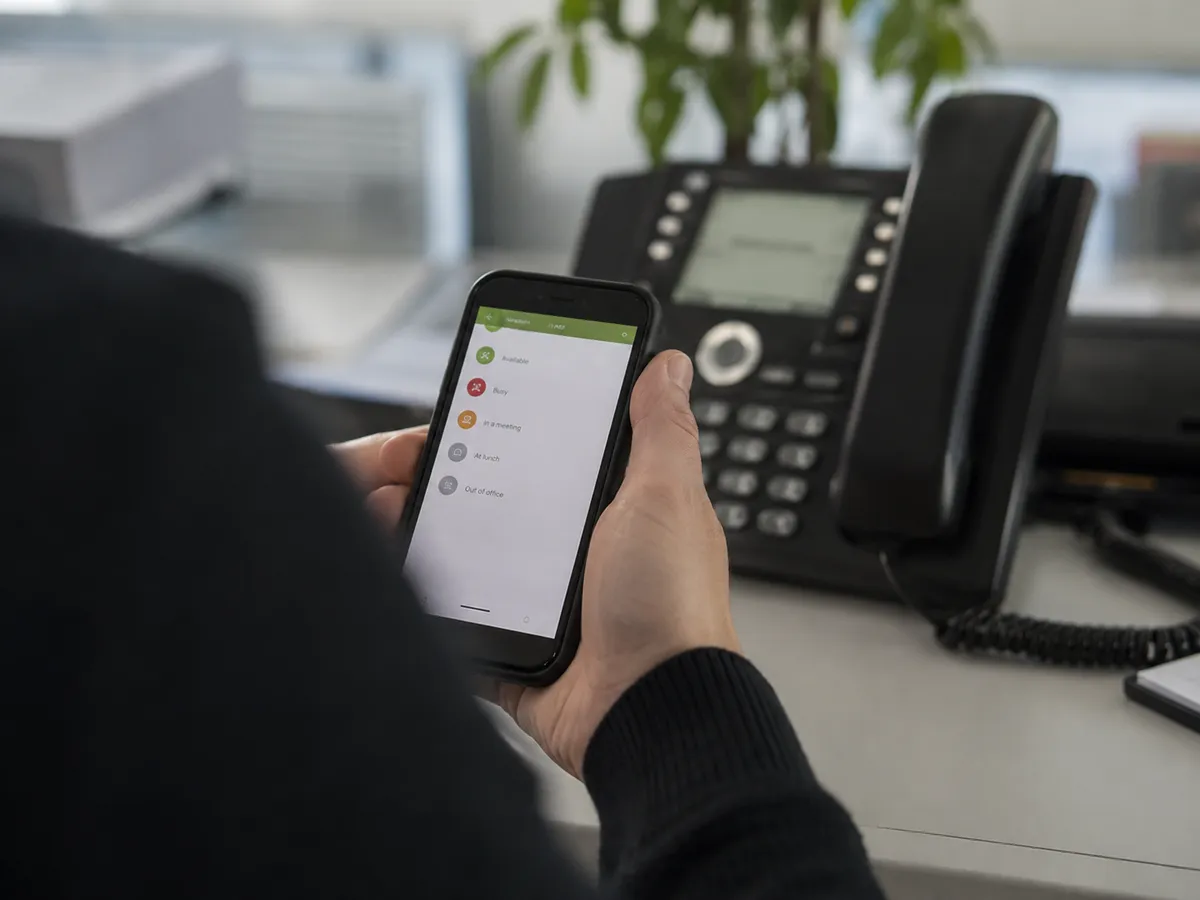 Kunde ruft den Auftragsstatus selbst auf dem Smartphone ab, das Telefon auf dem Schreibtisch bleibt still